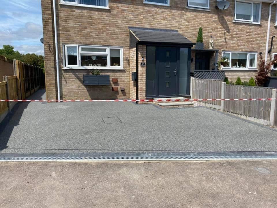 Resin-bound driveway outside a brick house