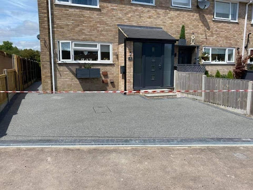 Grey resin driveway in front of brick house